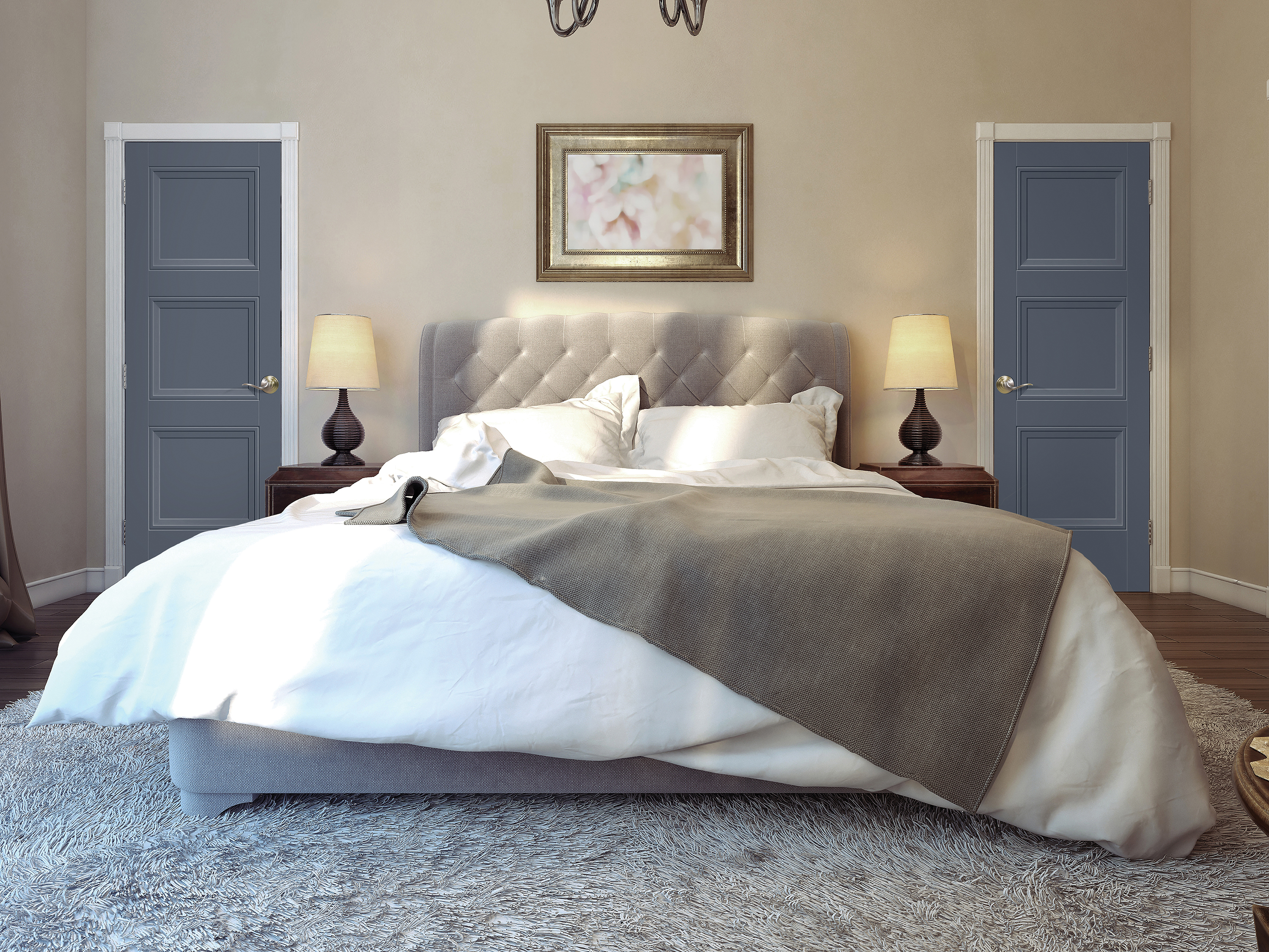A full-on view of a bed in a primary bedroom with gray blankets, beige walls and two navy blue three-panel doors, one on each side of the headboard